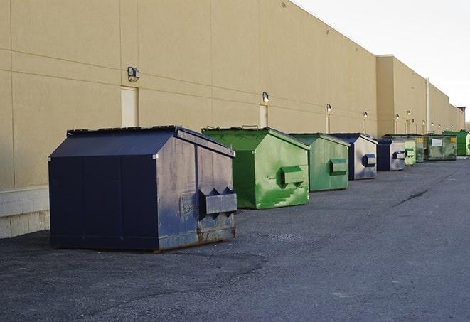 a row of yellow and blue dumpsters at a construction site in Glen Rock, NJ